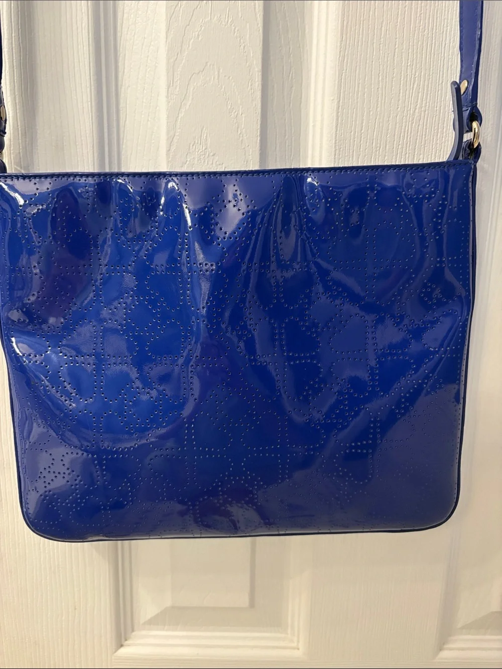 Kate Spade heart perforated patent leather crossbody in cobalt blue.